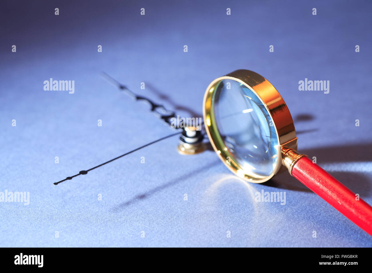 Time research. Closeup of magnifying glass near clock Stock Photo