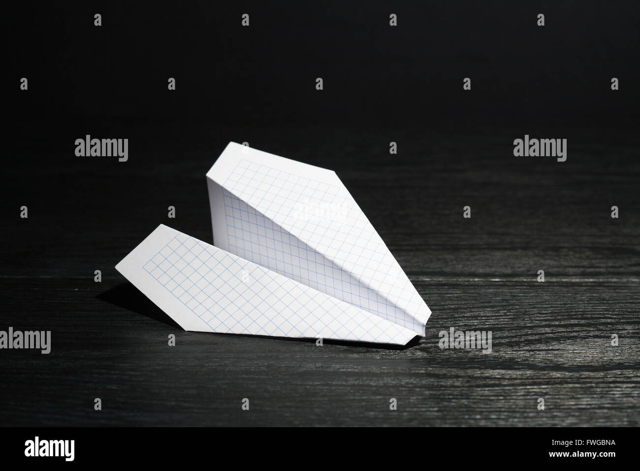 White paper airplane on dark background Stock Photo - Alamy