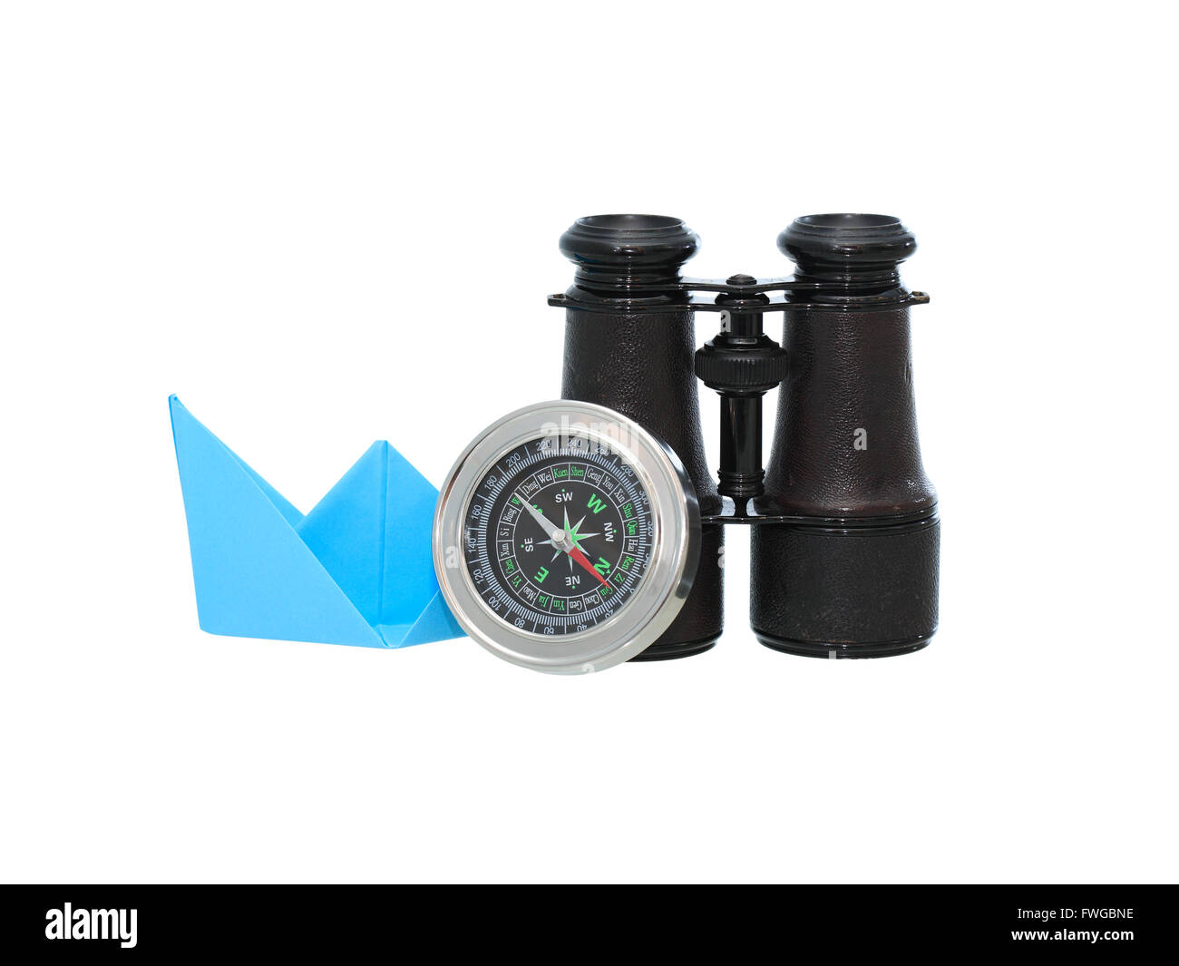 Blue paper boat and binoculars near compass. Isolated on white background with clipping path Stock Photo
