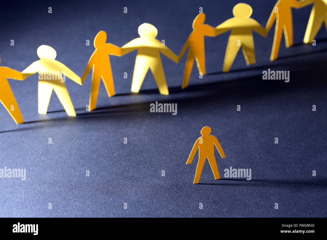 Confrontation concept. Yellow paper man against crowd in a row on dark Stock Photo