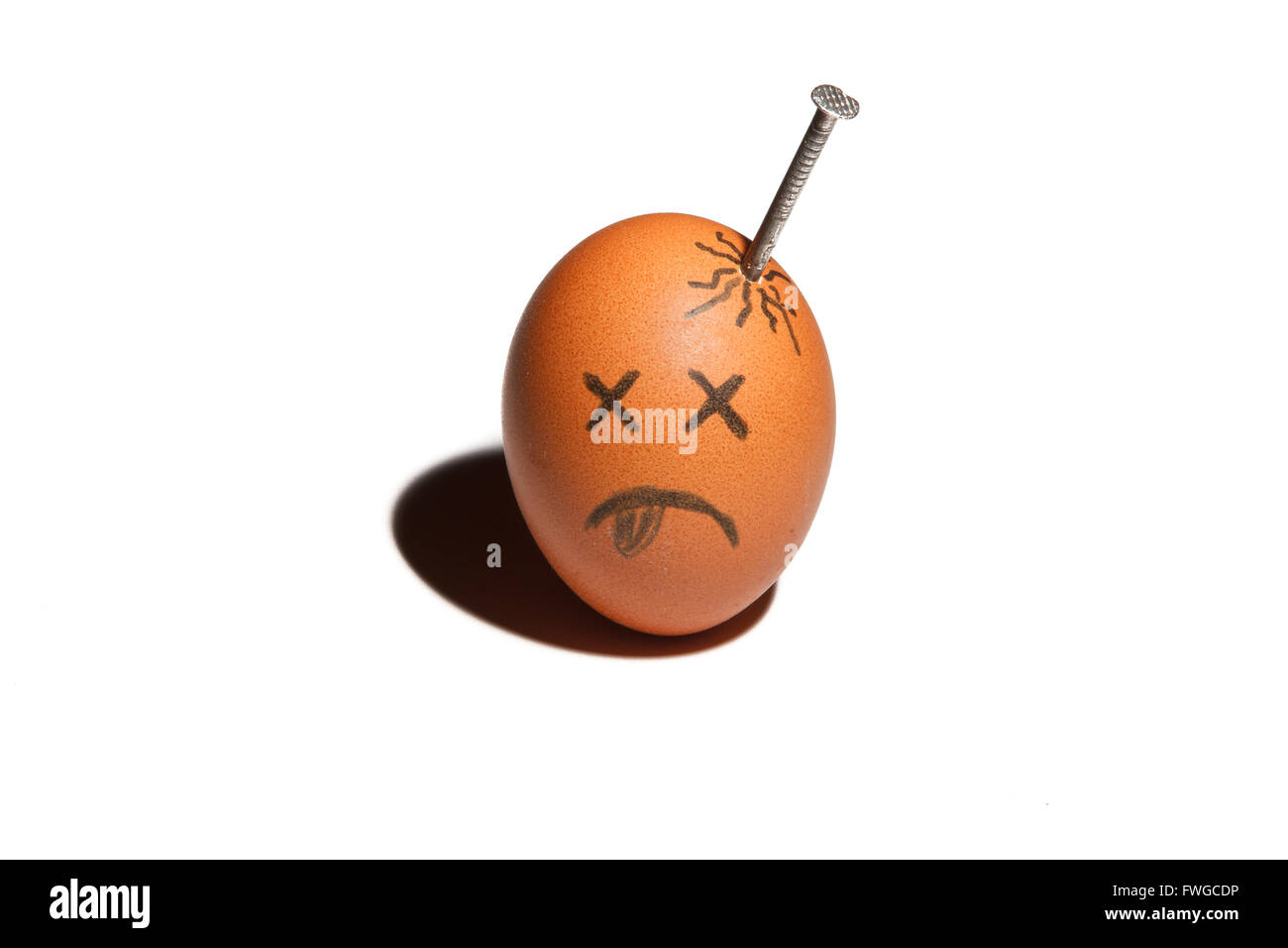 Sad egg character with nail in in the head isolated over white background Stock Photo
