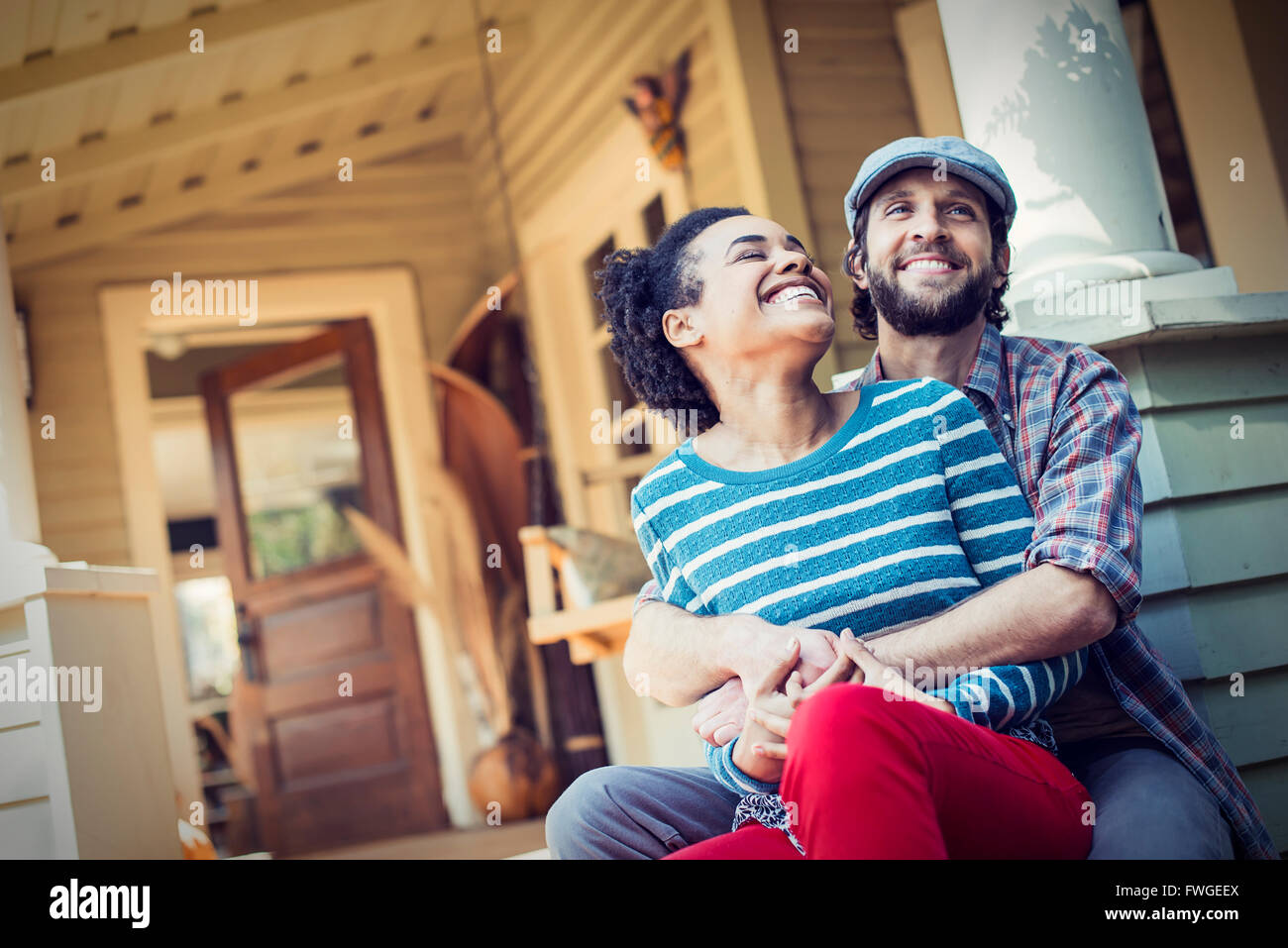 A Couple A Man And Woman Seated On The Porch Steps Laughing Stock a-couple-a-man-and-woman-seated-on-the-porch-steps-laughing-stock