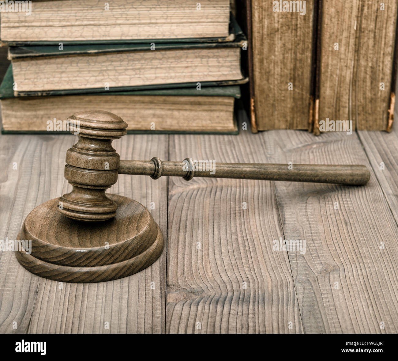 Judges gavel with soundboard and old books on wooden background. Auctioneer hammer Stock Photo