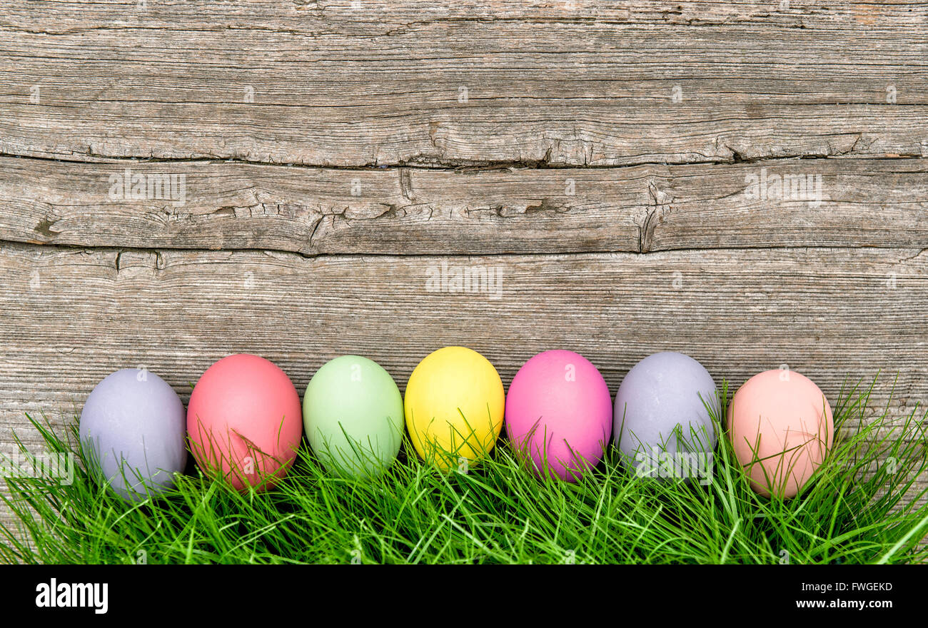 Easter eggs in green grass on rustic wooden background Stock Photo - Alamy