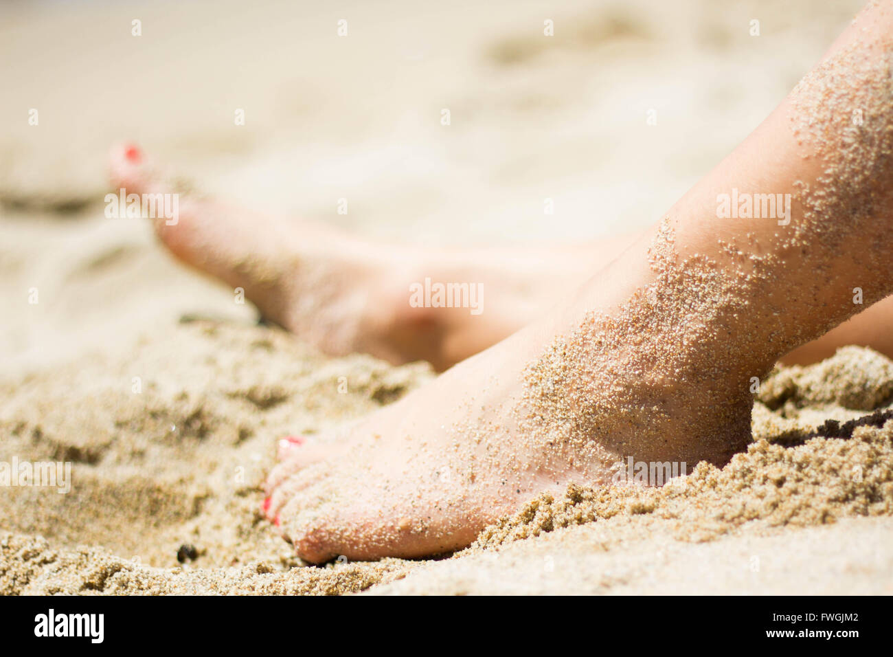 Close-Up View Of Woman's Legs On Beach Stock Photo