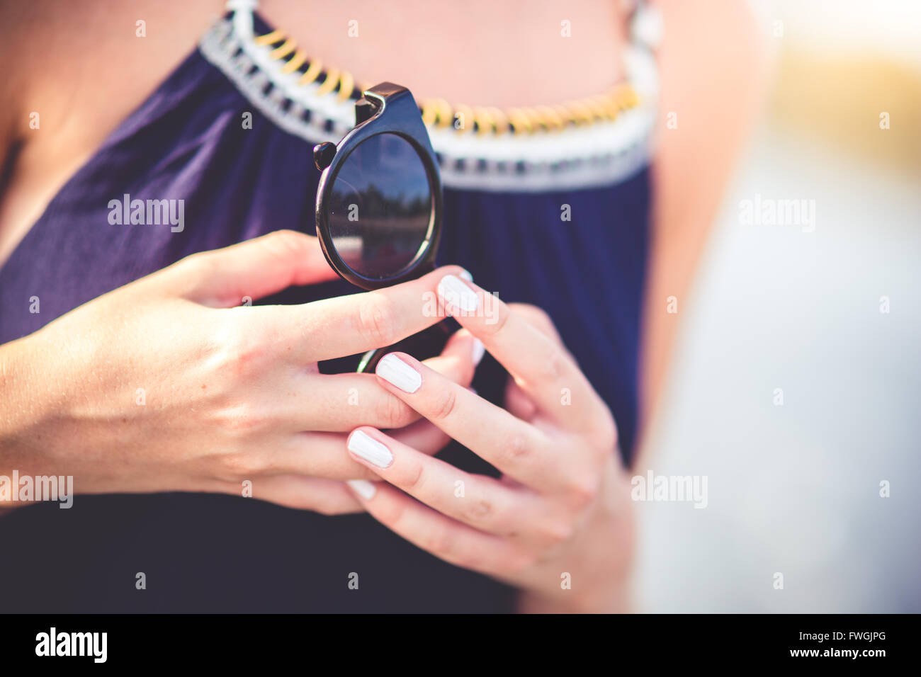 Midsection of Woman Holding Sunglasses Stock Photo