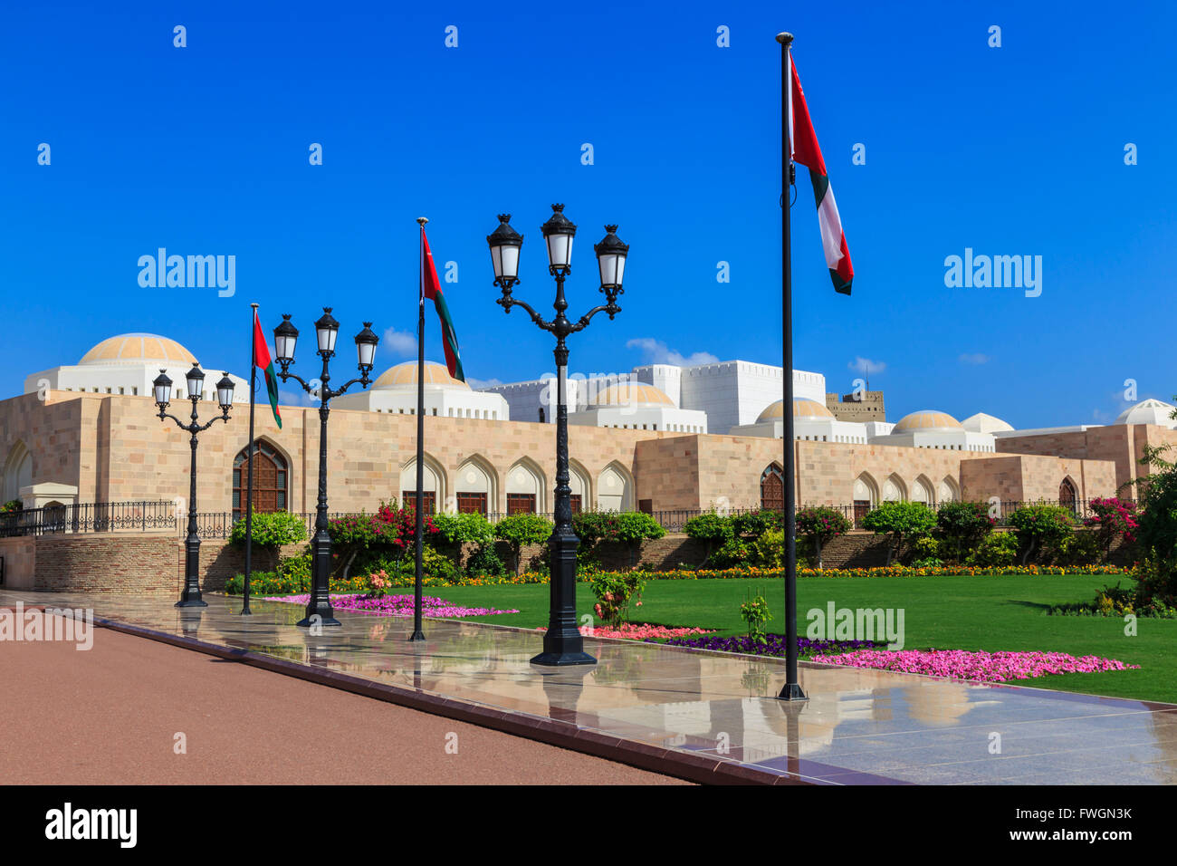 Polished pavements, National Flags, lush lawns and flowers in bloom, Sultan's Palace, Old Muscat, Oman, Middle East Stock Photo