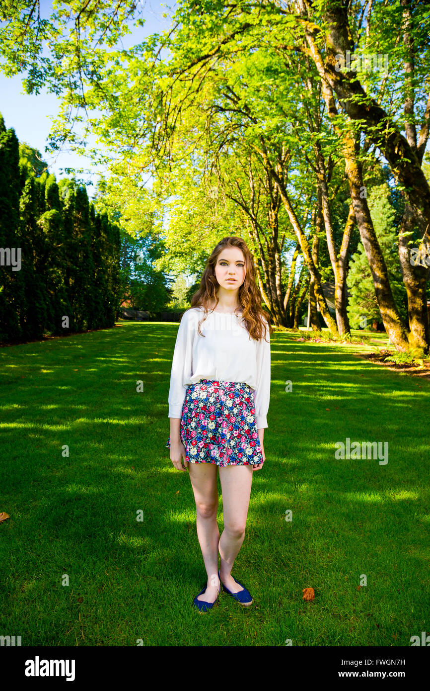 A beautiful young girl poses for a fashion style portrait outdoors at a