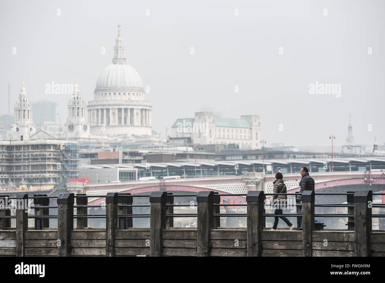 Couple on a pier overlooking St. Paul's Cathedral on the banks of the River Thames, South Bank, London, England, United Kingdom Stock Photo
