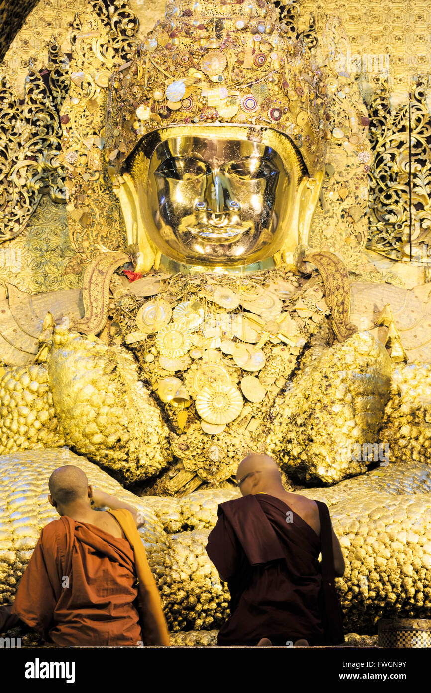 Mahamuni Paya, devotees praying and pressing gold leaf onto the Mahamuni buddha statue, Mandalay, Myanmar Stock Photo