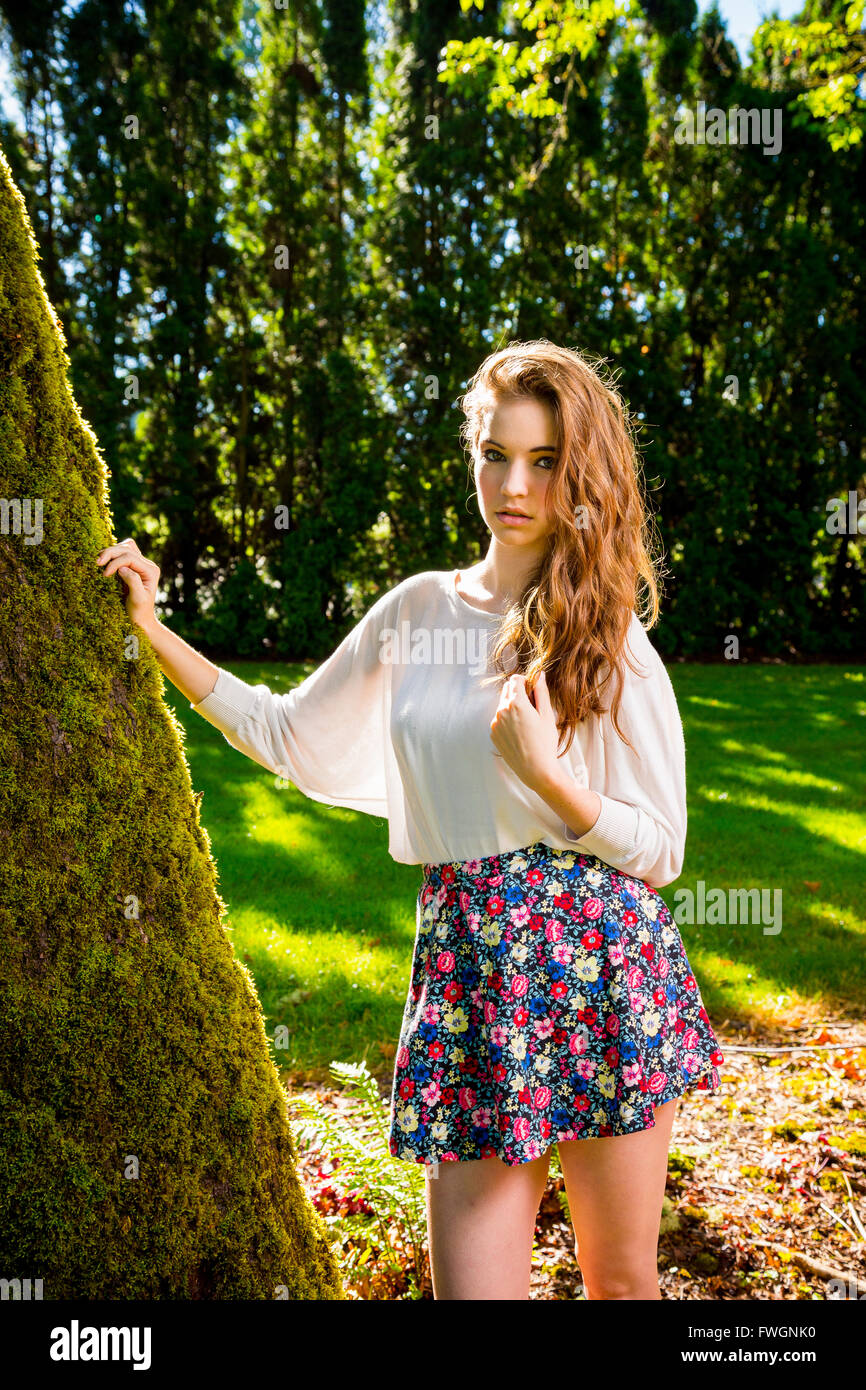 Outdoor portrait of young, beautiful, fashionable smiling girl posing in a  stylish, feminine white skirt and sneakers Stock Photo - Alamy