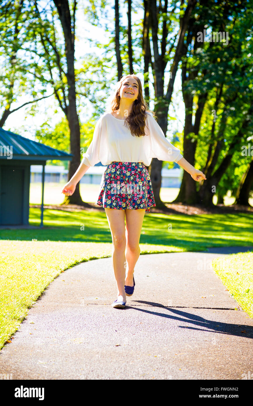 A beautiful young girl poses for a fashion style portrait outdoors at a ...