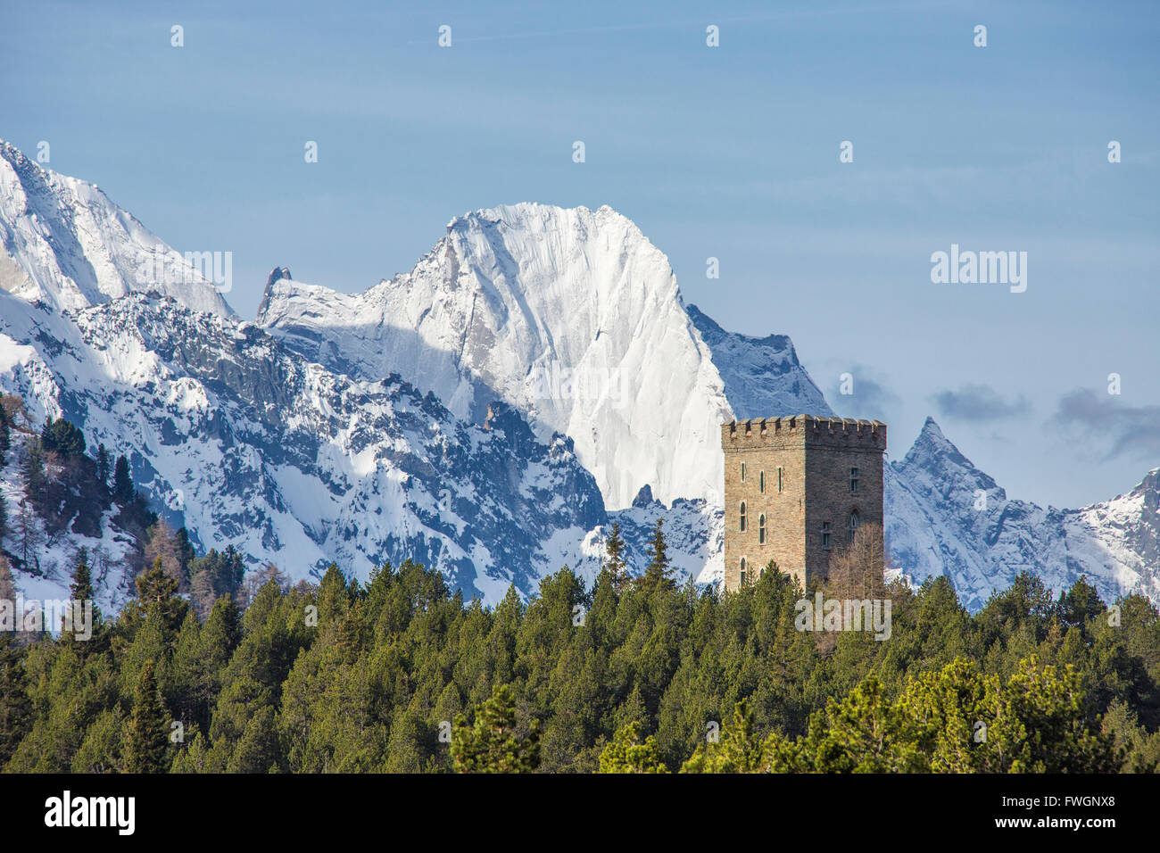 The Belvedere Tower frames the snowy peaks and Peak Badile on a spring day, Maloja Pass, Canton of Graubunden, Switzerland Stock Photo