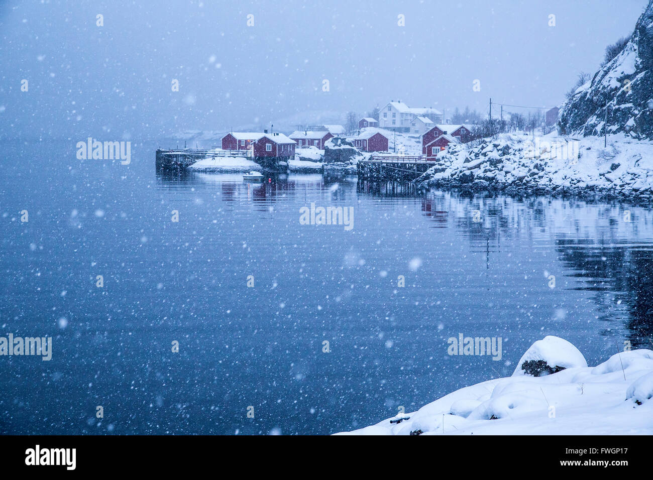 Heavy snowfall on the fishing village and the icy sea, Nusfjord, Lofoten Islands, Arctic, Norway, Scandinavia, Europe Stock Photo