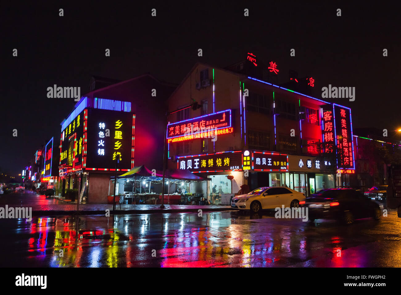 Hangzhou, China - December 3, 2014: Chinese night city street with colorful advertisement neon lights on walls Stock Photo