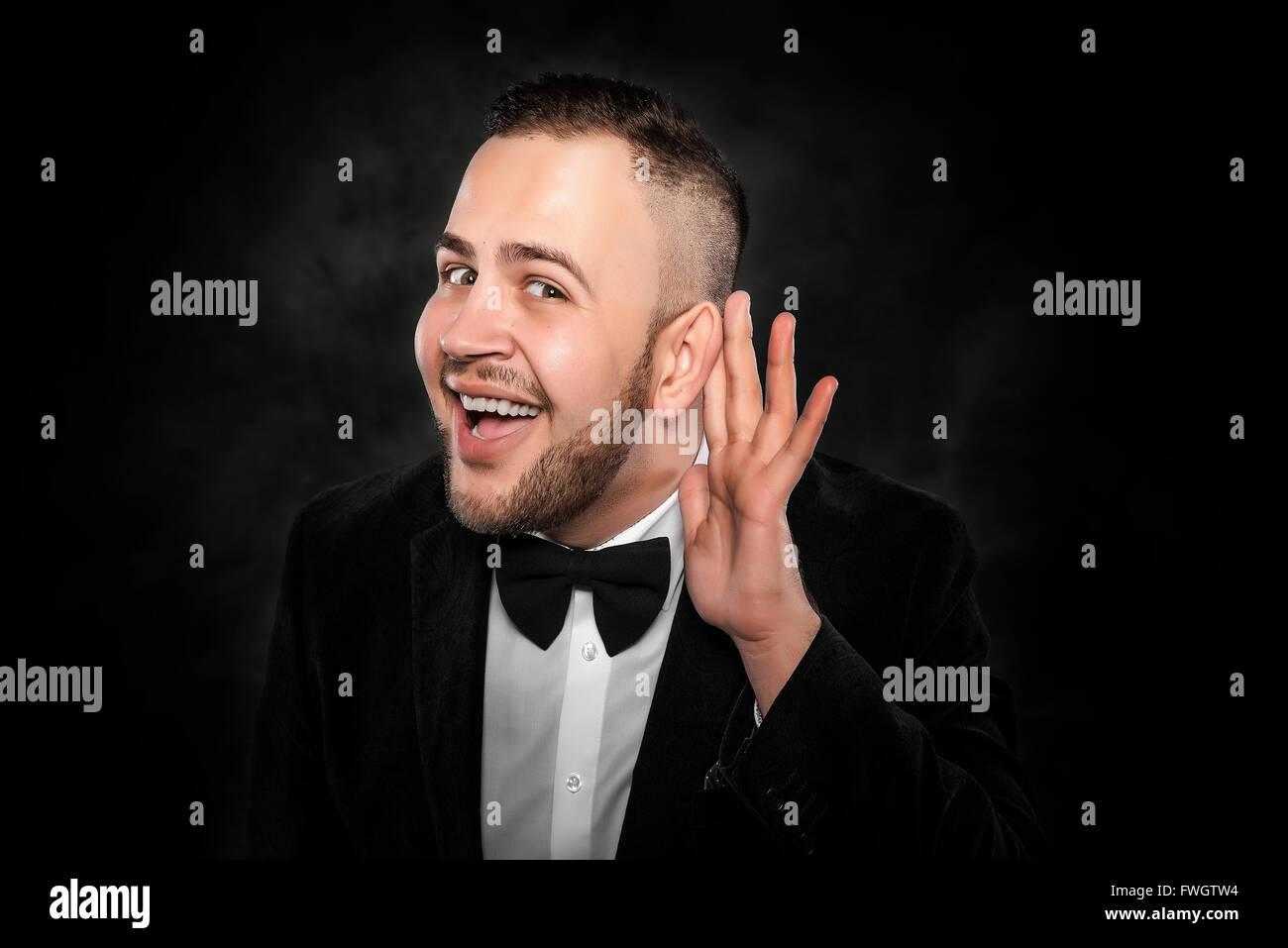 Man with big ear listening something on a dark background Stock Photo Alamy