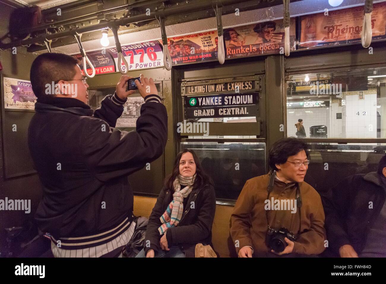 New York, USA. 5th Apr, 2016. Baseball fans take photos on the 'Nostalgia Special' train to Yankee Stadium in New York, the United States, April 5, 2016. The New York Metropolitan Transportation Authority rolls out a vintage train to take baseball fans to Yankee Stadium for the season's home opening game. Dubbed 'the Nostalgia Special', the antique train dates back to 1917, and was retired in the early 1960s. Credit:  Li Changxiang/Xinhua/Alamy Live News Stock Photo