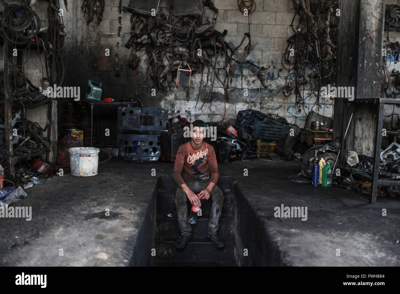 Gaza. 5th Apr, 2016. Palestinian boy Debes Talateni, 13, who works as mechanic to help his father support their family, sits at a garage in Gaza City on April 5, 2016. Many Palestinian young boys are trying to make a living and support their family. © Wissam Nassar/Xinhua/Alamy Live News Stock Photo