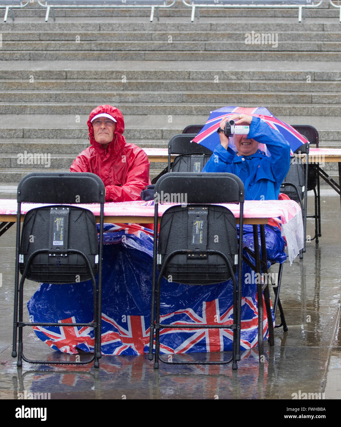 Trafalgar Square, London, June 12th 2016. Rain greets Londoners and visitors to the capital's Trafalgar Square as the Mayor hosts a Patron’s Lunch in celebration of The Queen’s 90th birthday. PICTURED: Undeterred and full of British spirit a couple refuse to let the rain dampen their day. Credit:  Paul Davey/Alamy Live News Stock Photo
