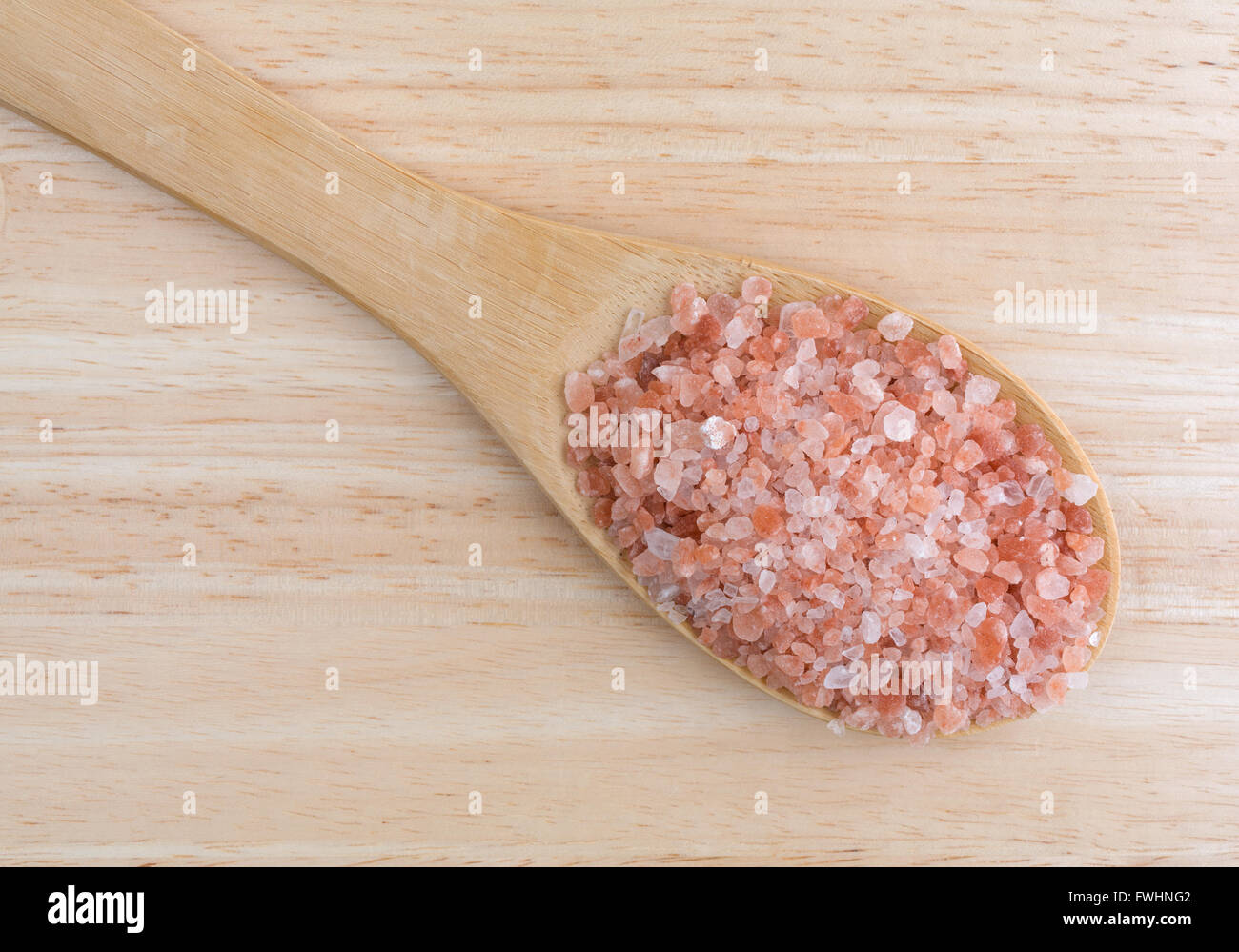 Top close view of a portion of Himalayan pink salt on a large kitchen spoon  upon a wood counter top Stock Photo - Alamy