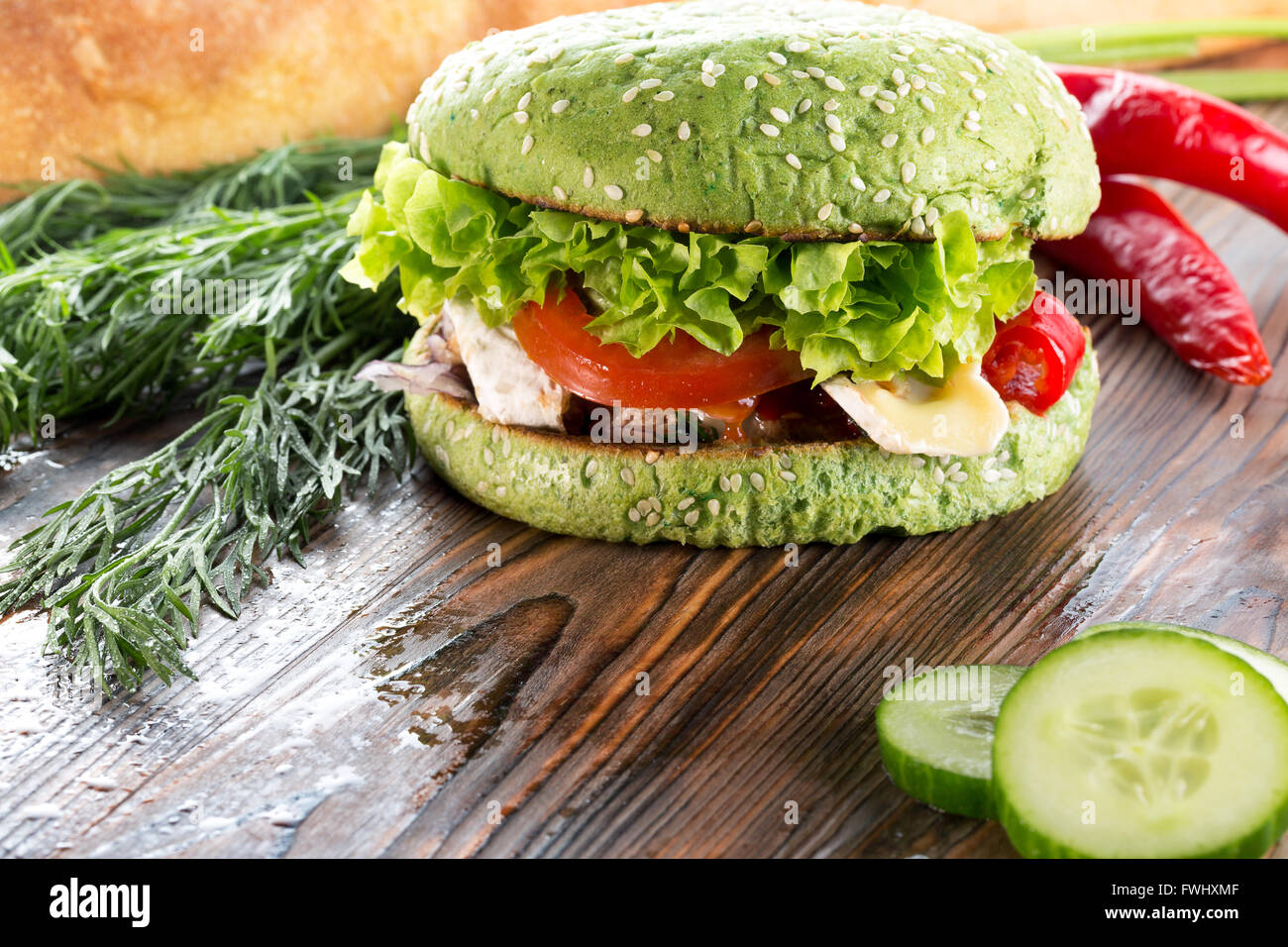 burger with green bun on wooden background. Stock Photo