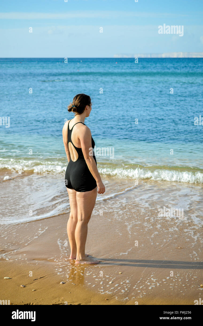 a beautiful lady in swimsuit looking at the sea Stock Photo