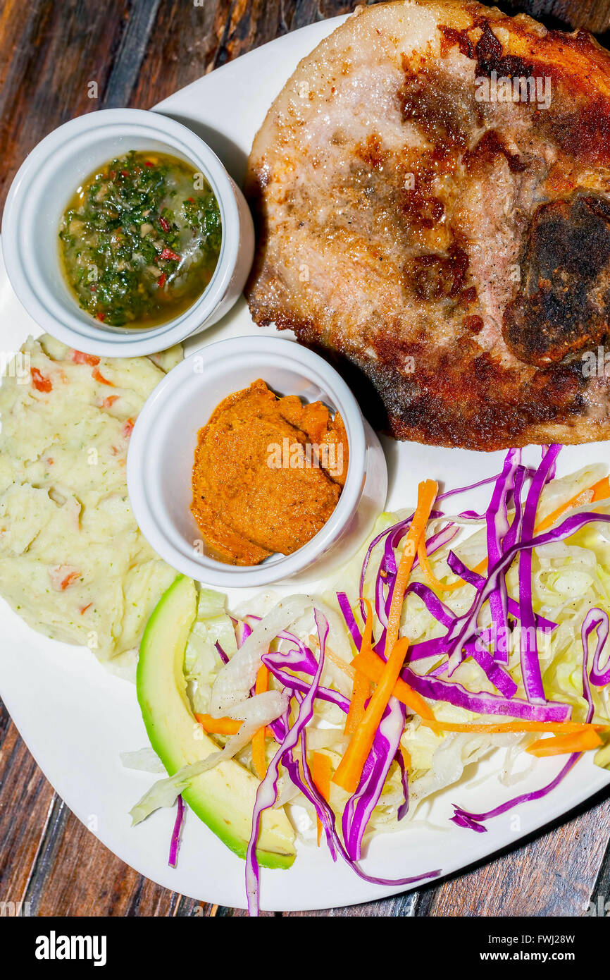 Grilled Pork With Mashed Potatoes, Honey Mustard And Chimichurri Sauce, Delicious Lunch Stock Photo