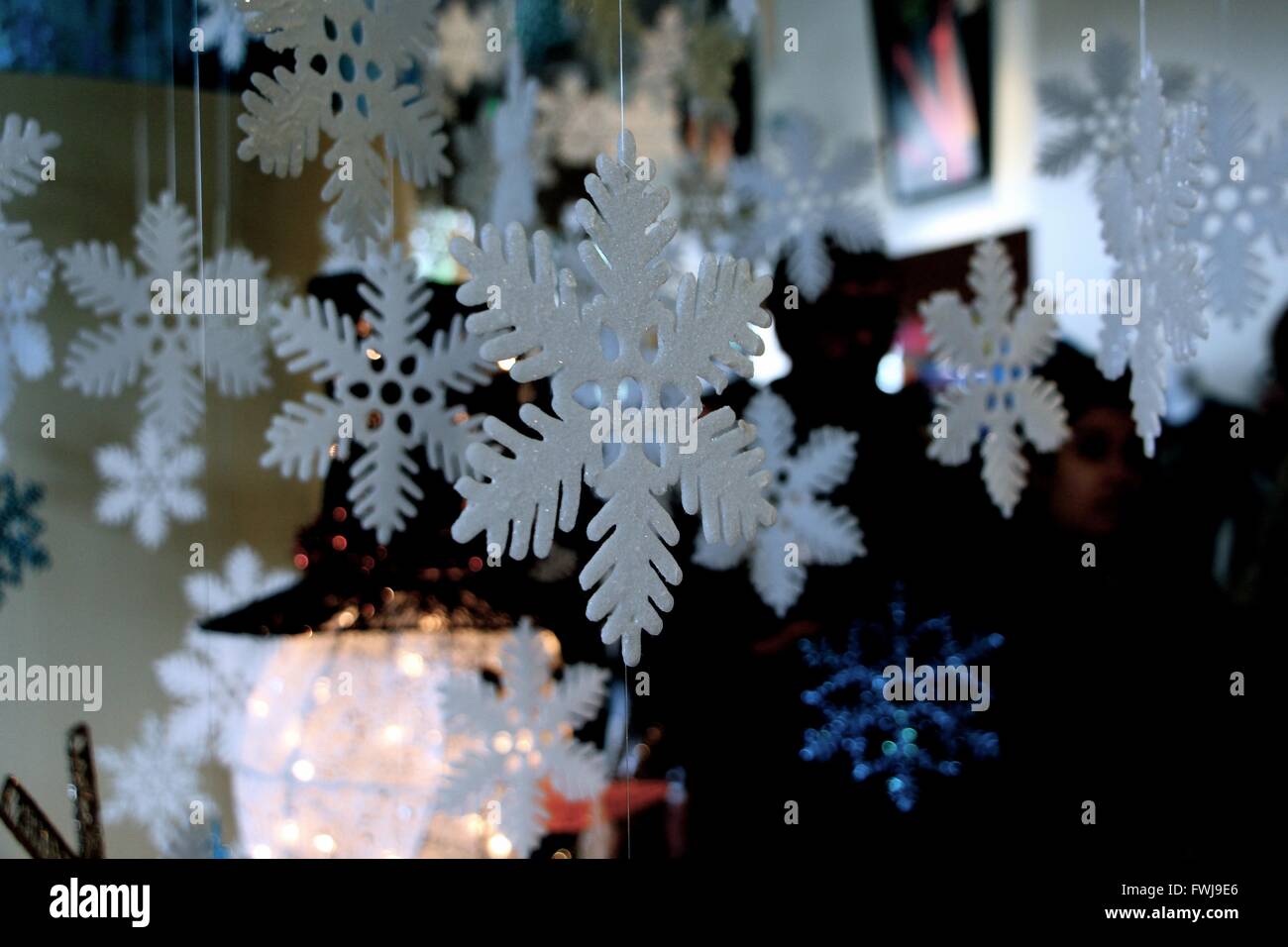 Close Up Of Snowflake Decorations Hanging At Home Stock Photo