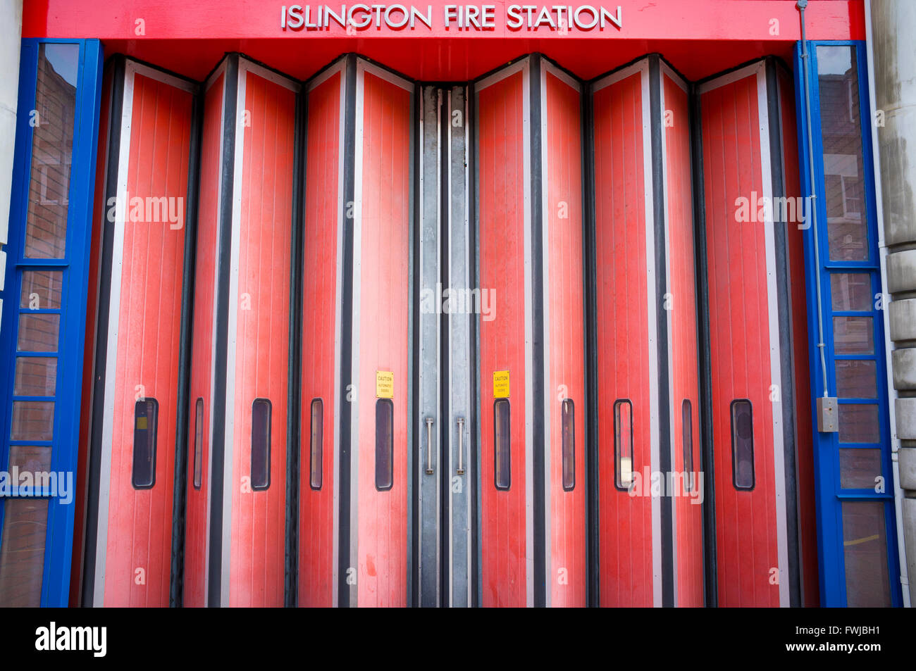 Red folding doors at Islington Fire Station, London Stock Photo - Alamy