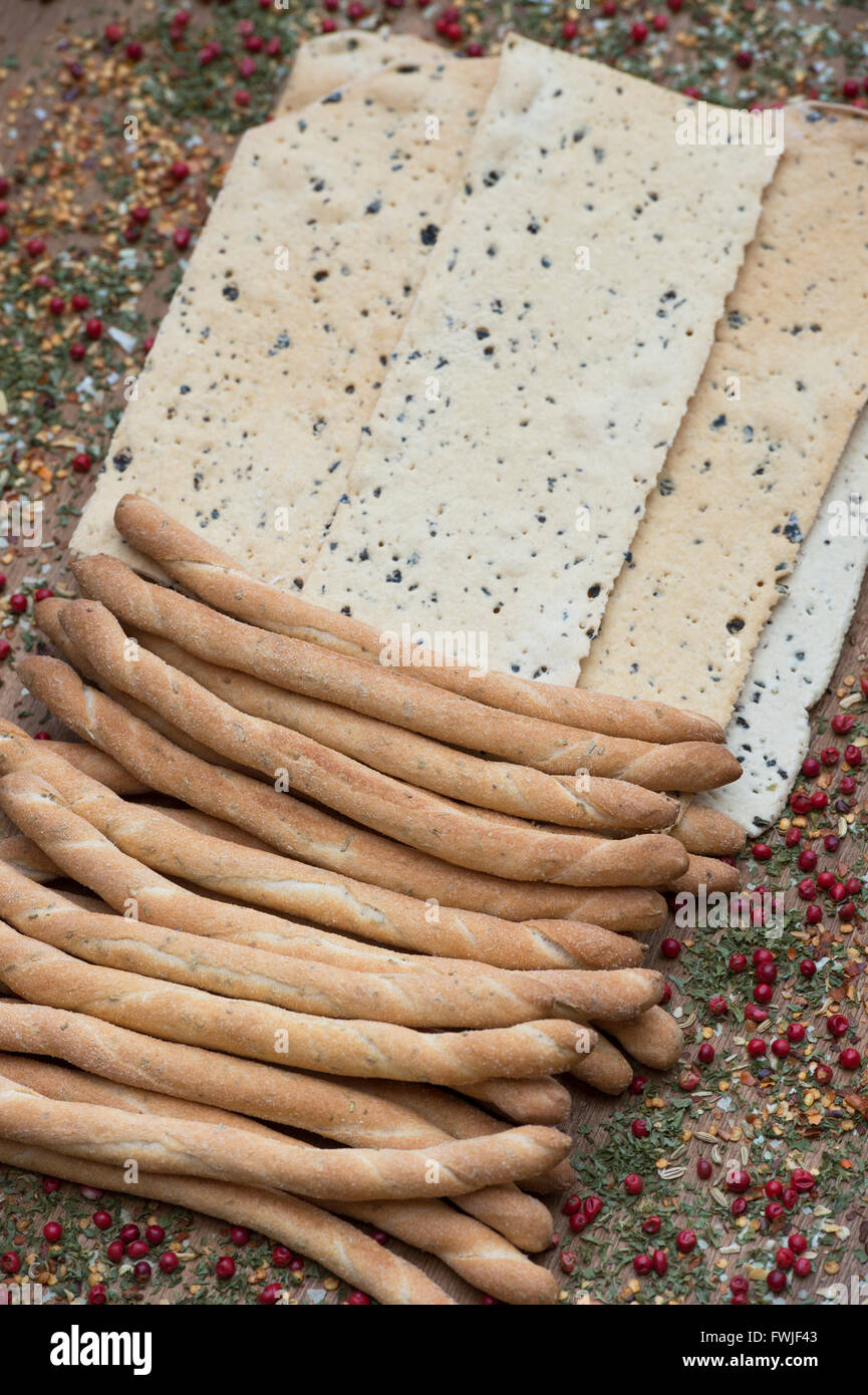 Italian Crispy flatbread / Croccante and Sesame rubato breadsticks on a dried herb and spice background Stock Photo