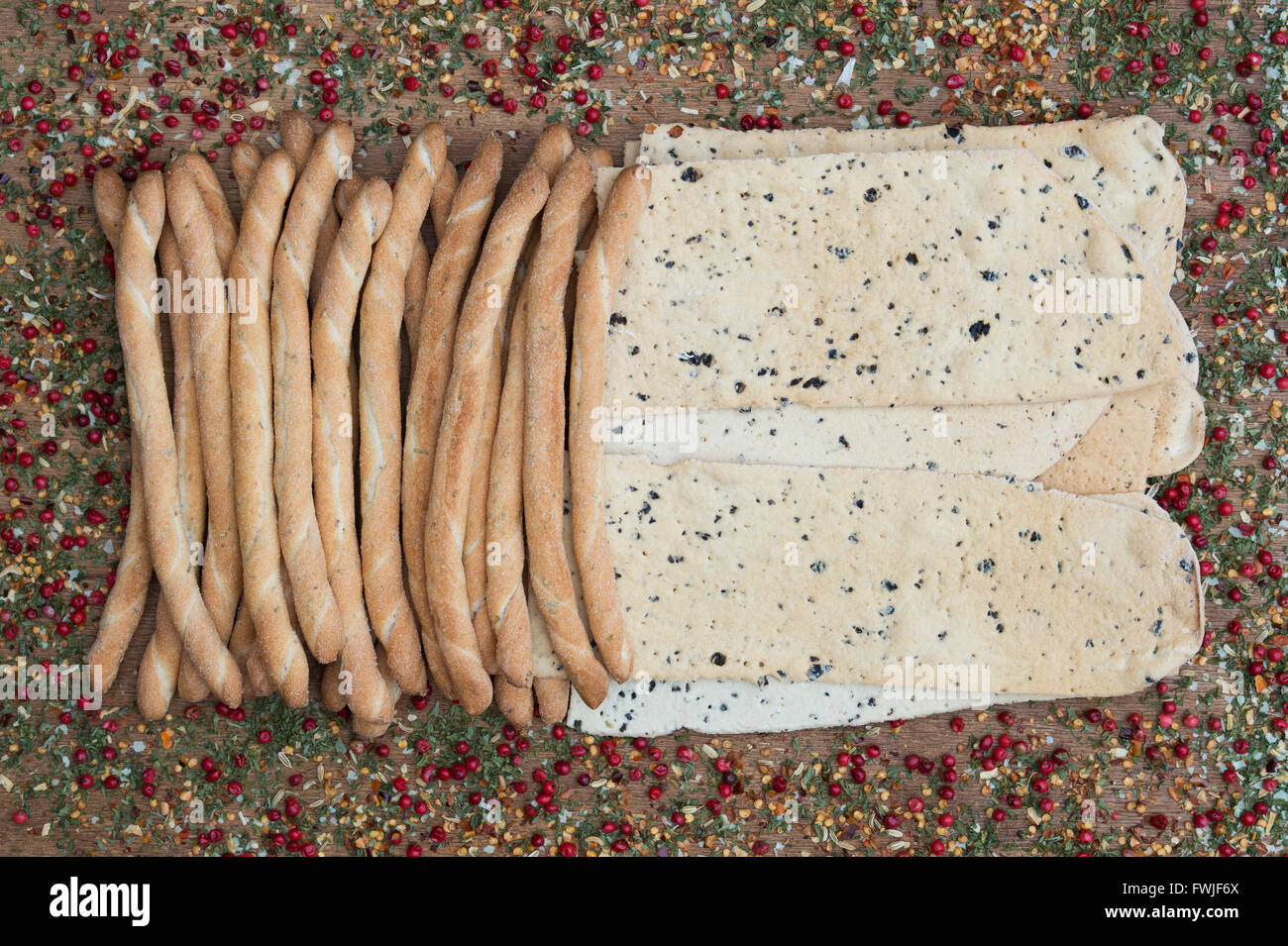 Italian Crispy flatbread / Croccante and Sesame rubato breadsticks on a dried herb and spice background Stock Photo