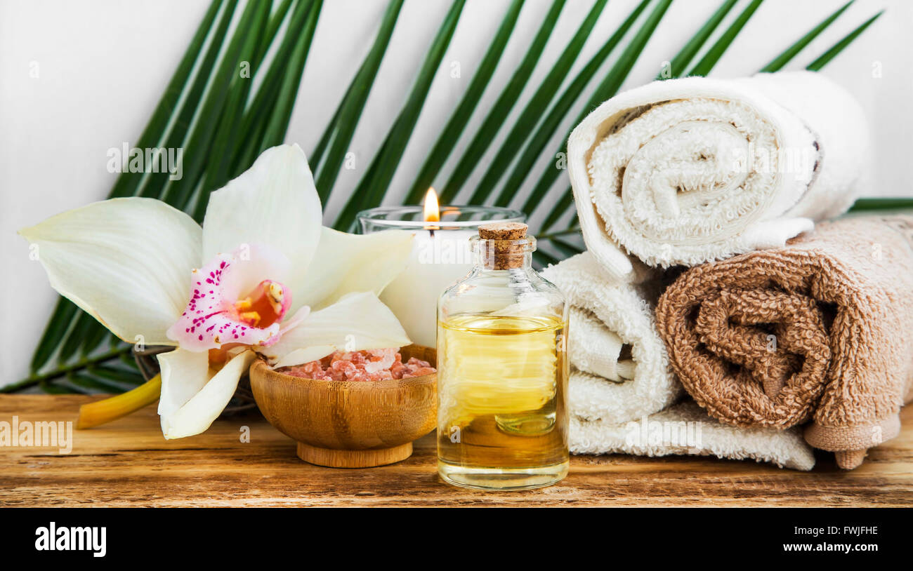 Spa orchid still life setting with body oil, towels and salt Stock Photo