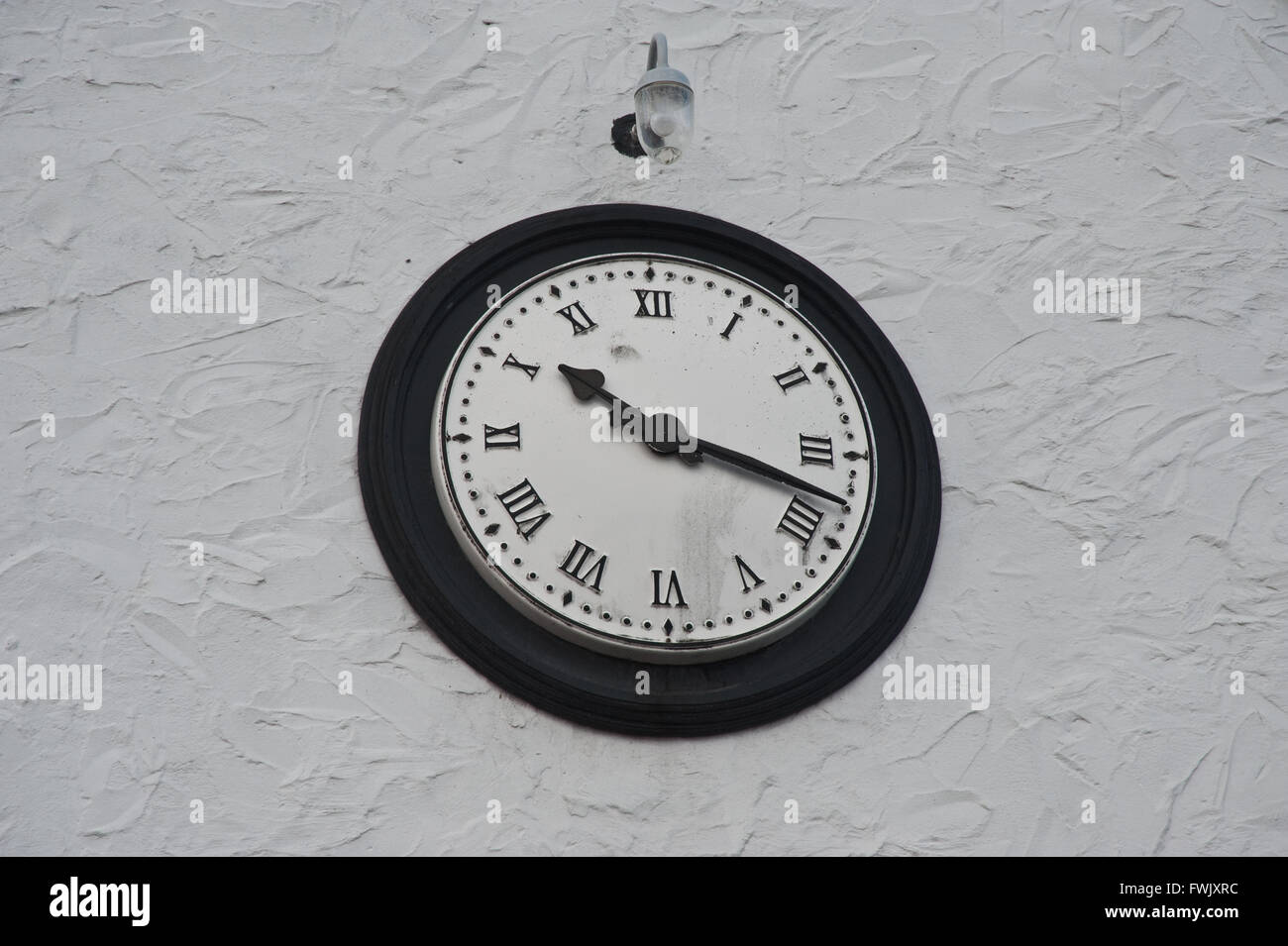 Clock on white wall Stock Photo Alamy