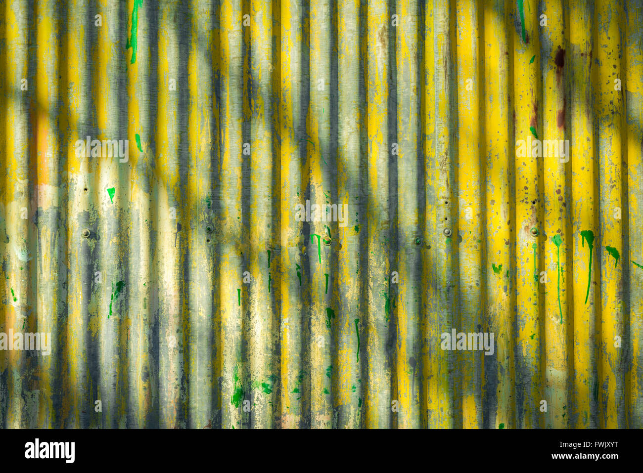 Corrugated iron wall surface background in yellow and grey Stock Photo
