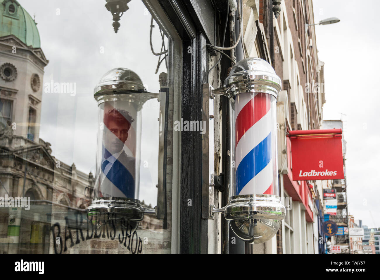 Barber's pole outside a barbers shop in London's Smithfield area, UK Stock Photo