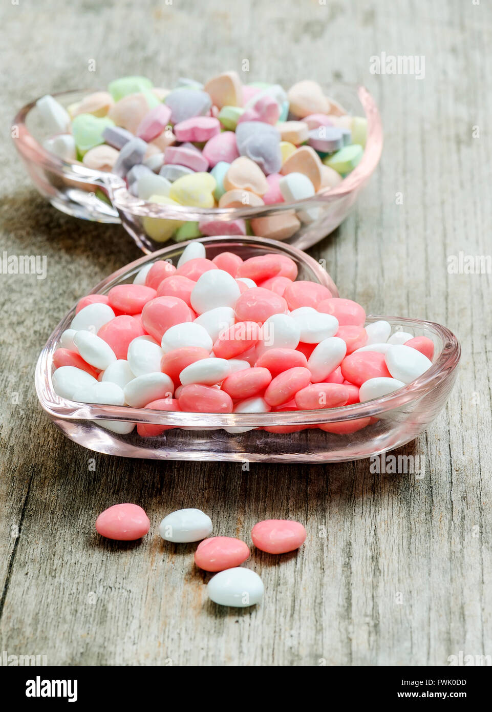 Colorful and sweet candies  in glass plate on wooden table. Stock Photo
