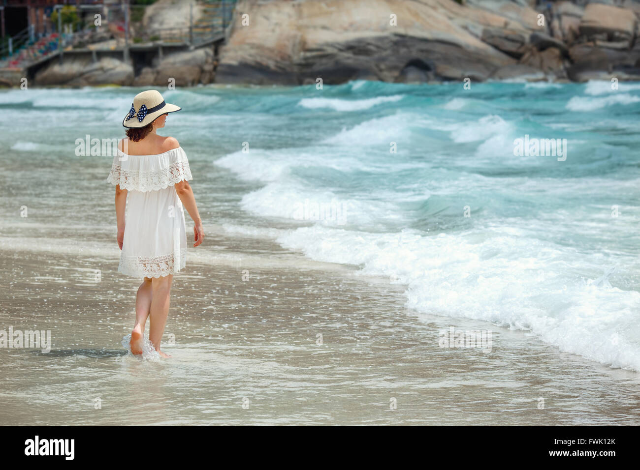 Woman with white clothe walking on the beach Stock Photo