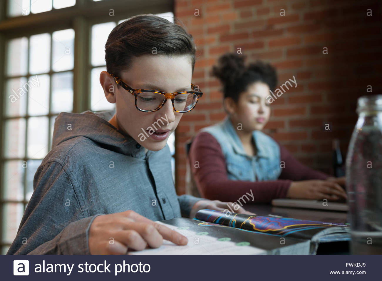 Boy doing homework in coffee shop Stock Photo Alamy
