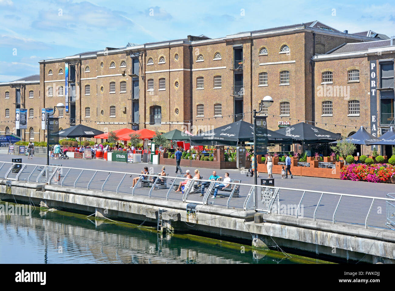 West India Docks old North Dock at Canary Wharf outdoor restaurant & converted warehouses buildings in London Docklands Isle of Dogs Tower Hamlets UK Stock Photo