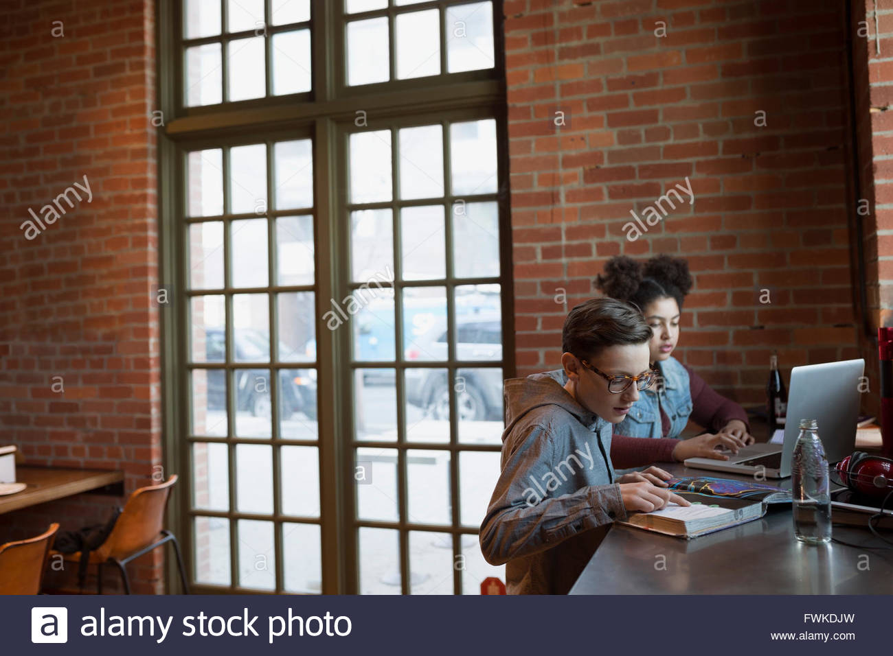 Blend girl doing homework in coffee shop Stock Photo Alamy