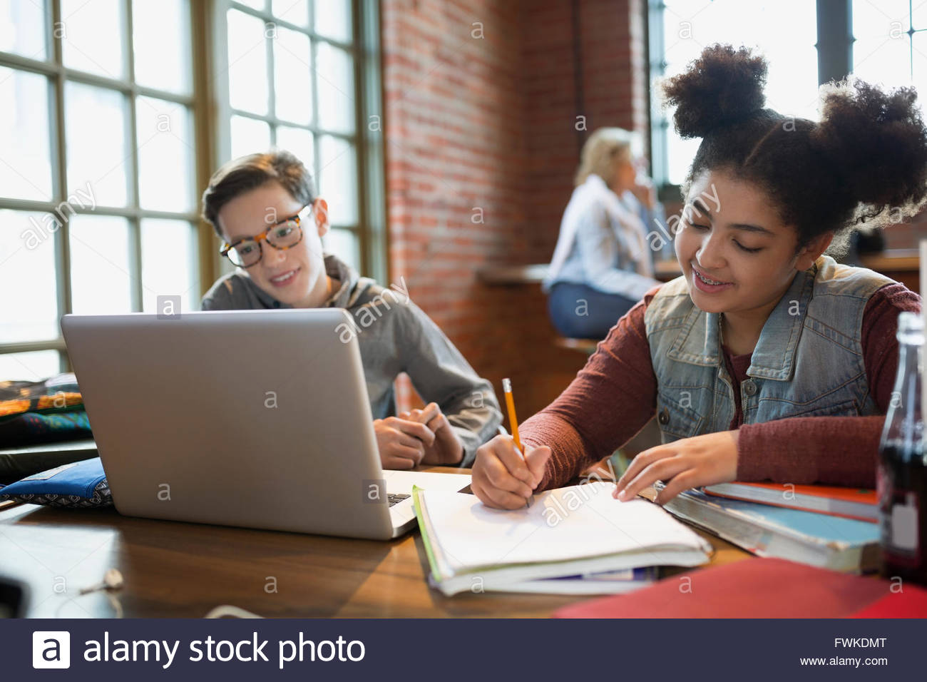 Boy and girl doing homework at laptop in coffee shop Stock Photo Alamy