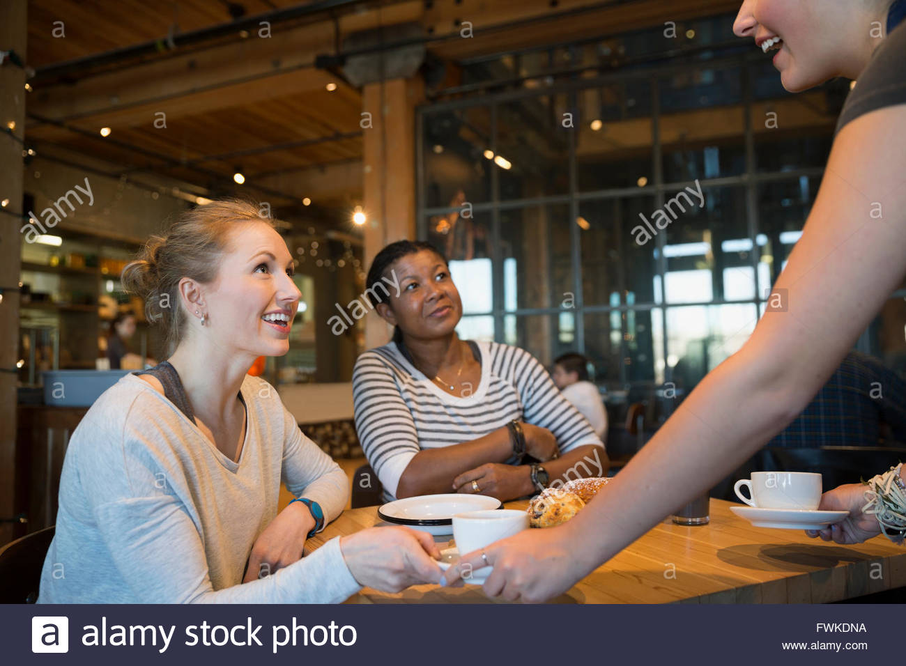 Bakery worker serving coffee to customers Stock Photo