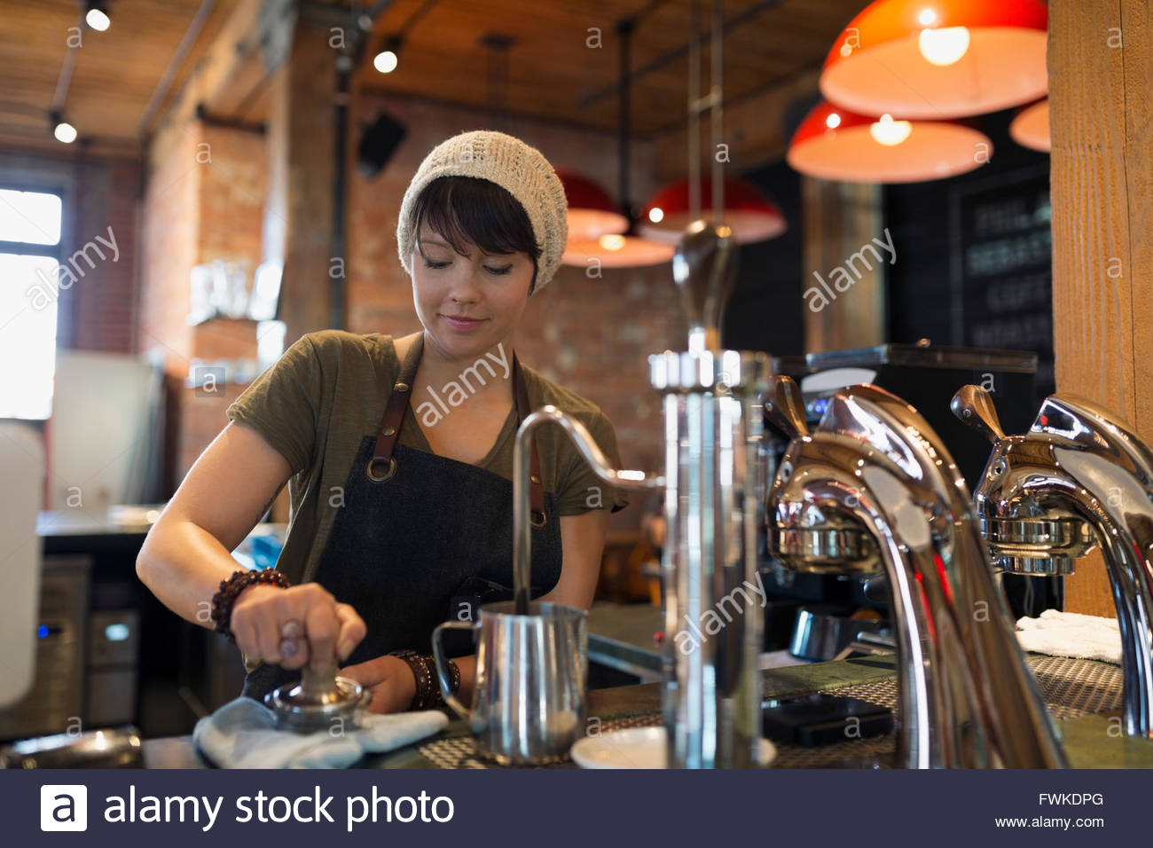 Barista pressing espresso with tamper in coffee shop Stock Photo