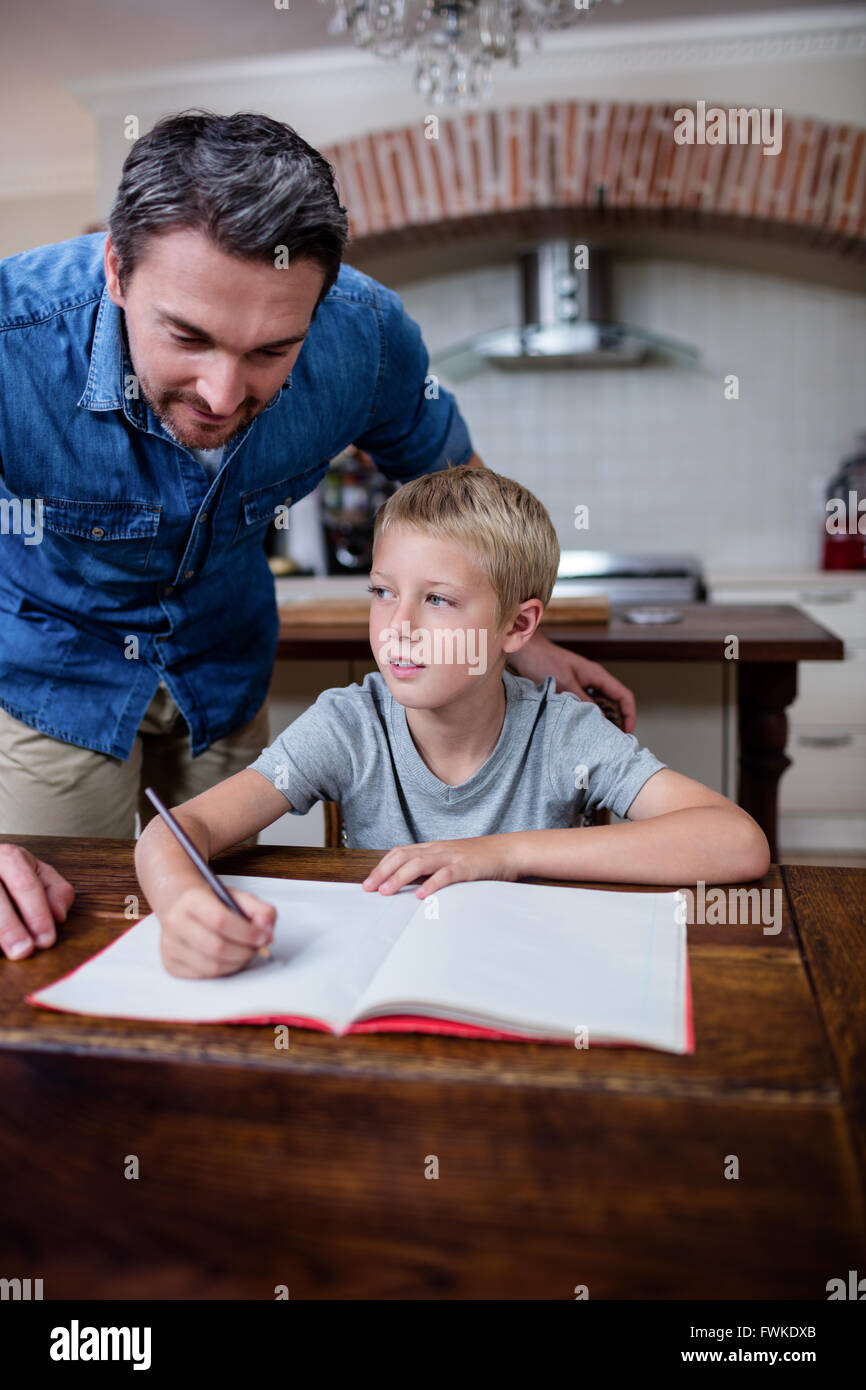Father helping son with his homework in kitchen Stock Photo - Alamy