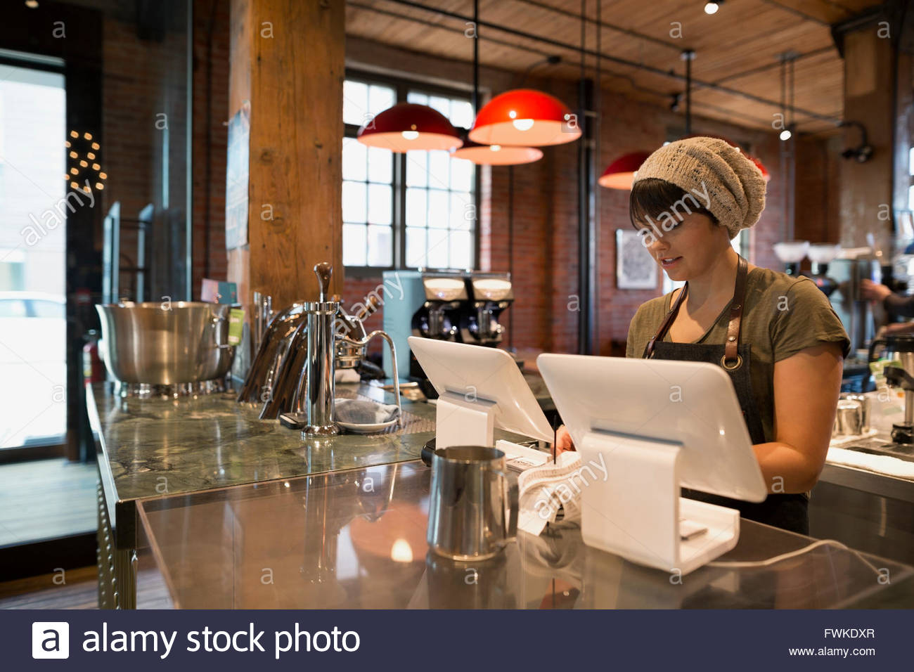 Barista cashier using digital tablet in coffee shop Stock Photo