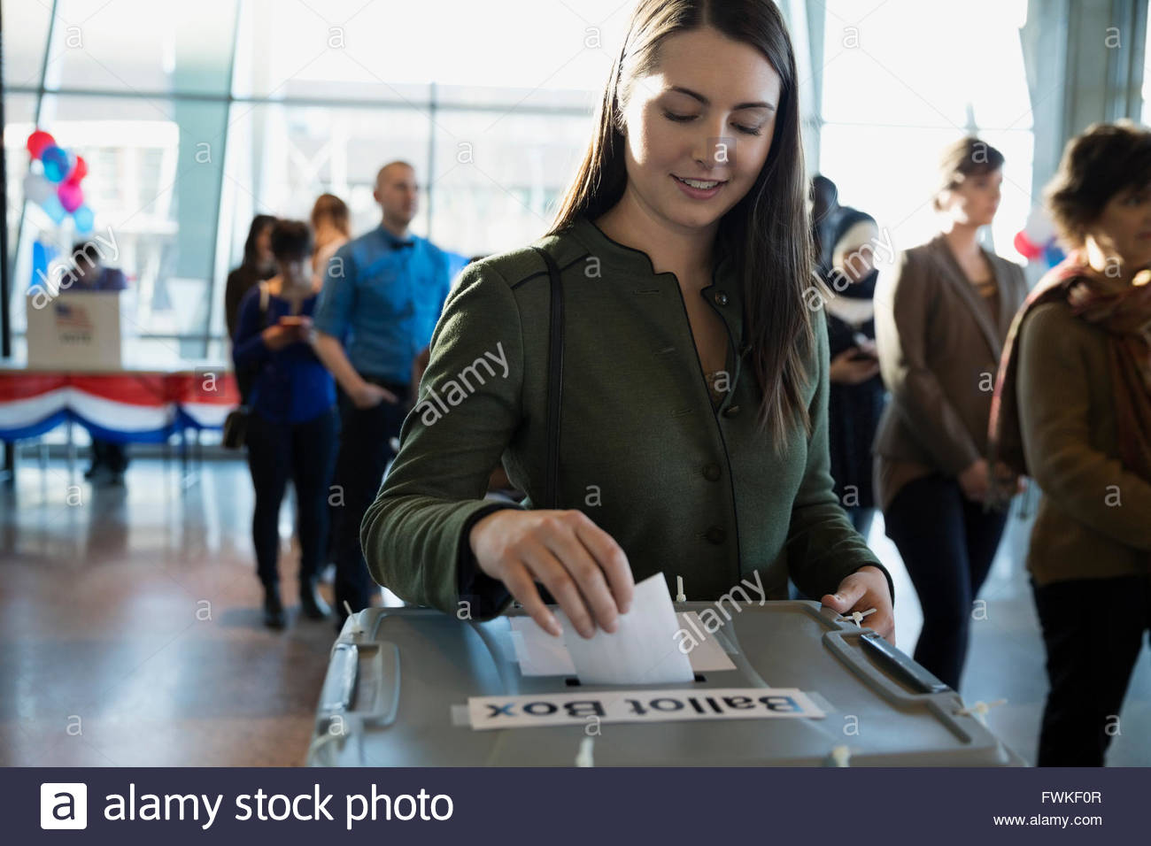 Voter placing ballot in ballot box polling place Stock Photo