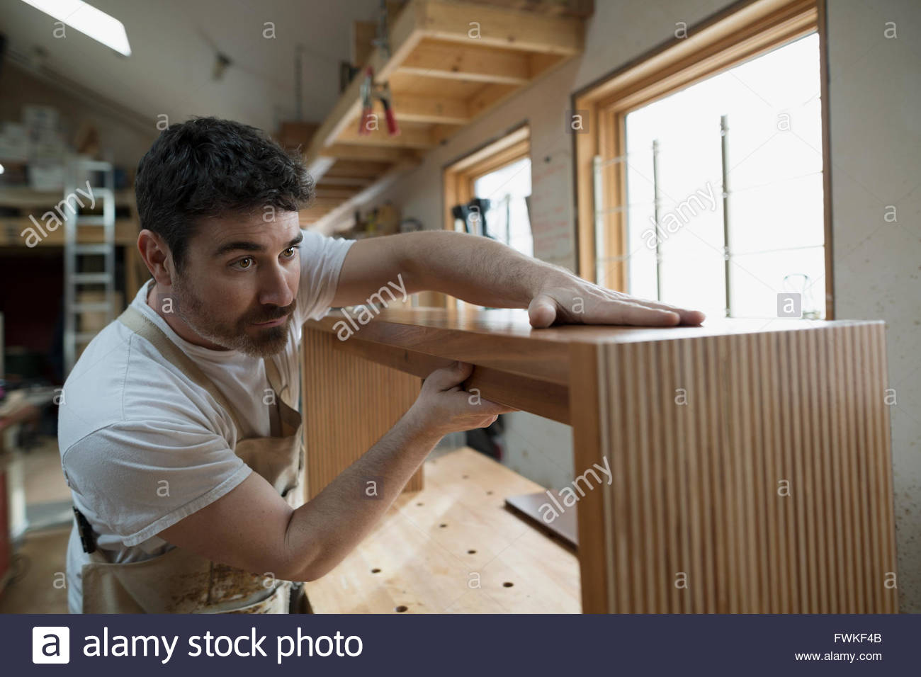 Carpenter assembling furniture in workshop Stock Photo