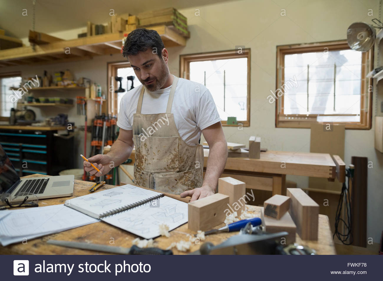Carpenter brainstorming and sketching in workshop Stock Photo