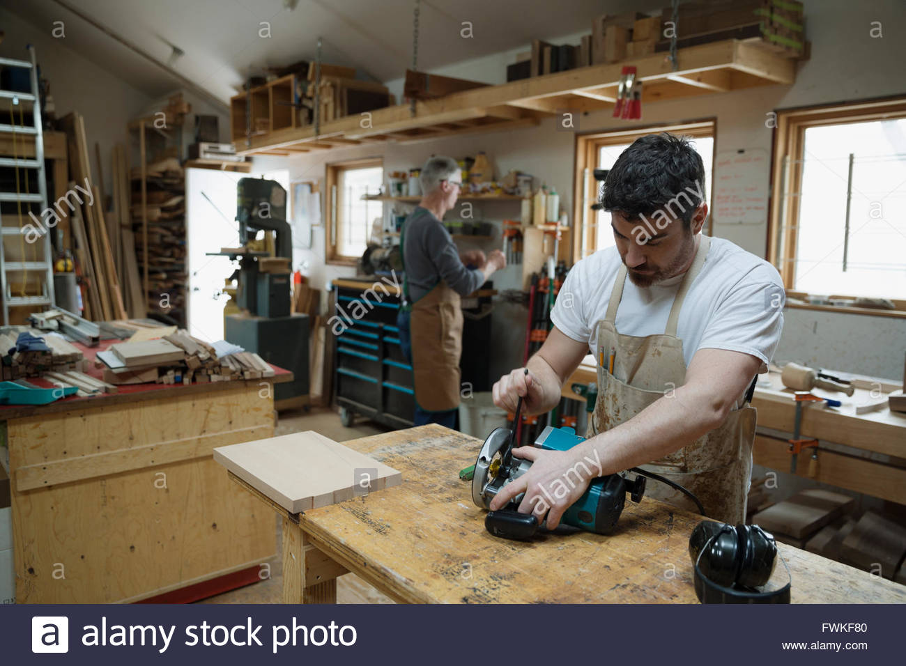 Carpenter adjusting hand saw in workshop Stock Photo