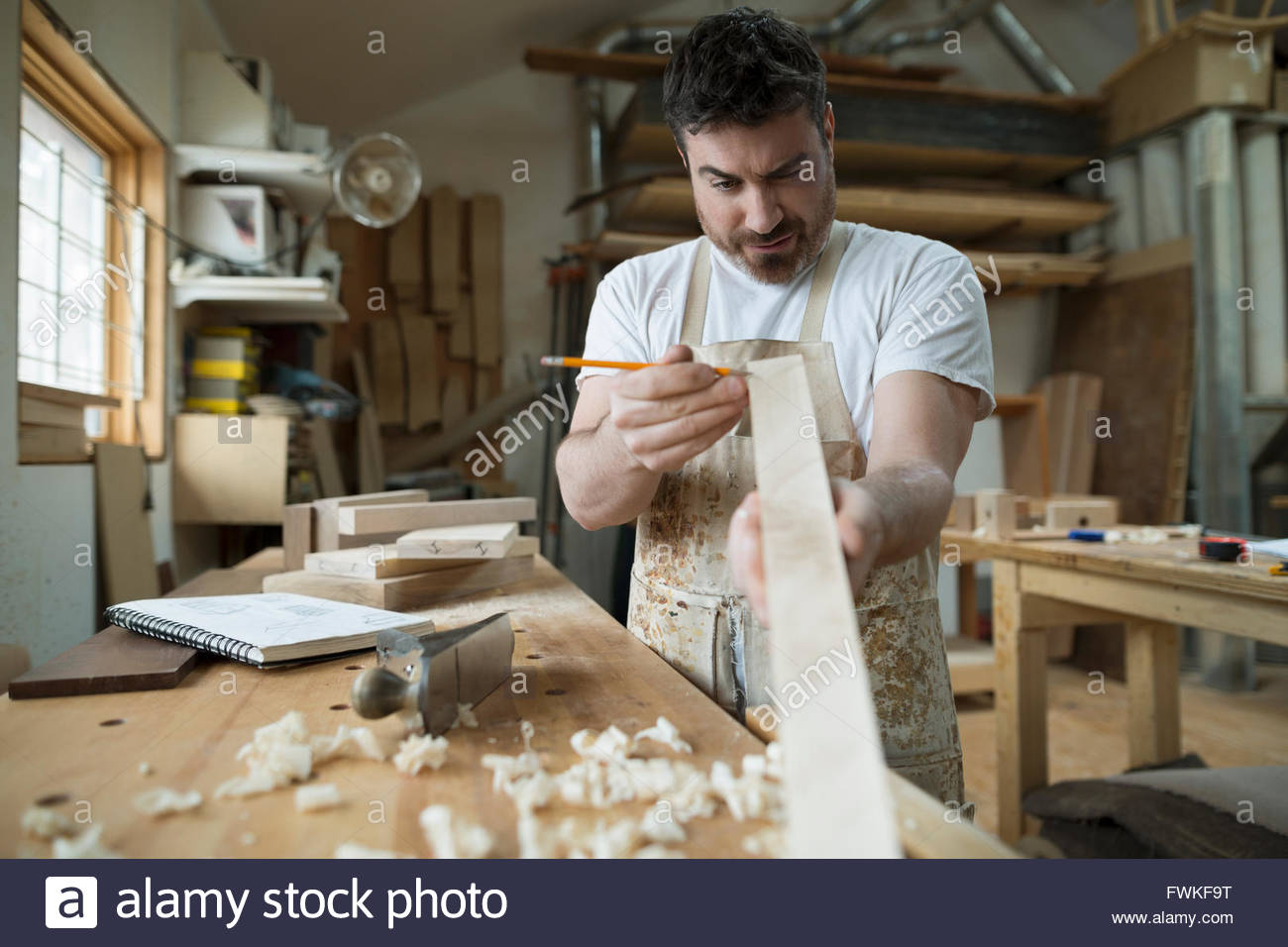 Carpenter marking wood in workshop Stock Photo - Alamy